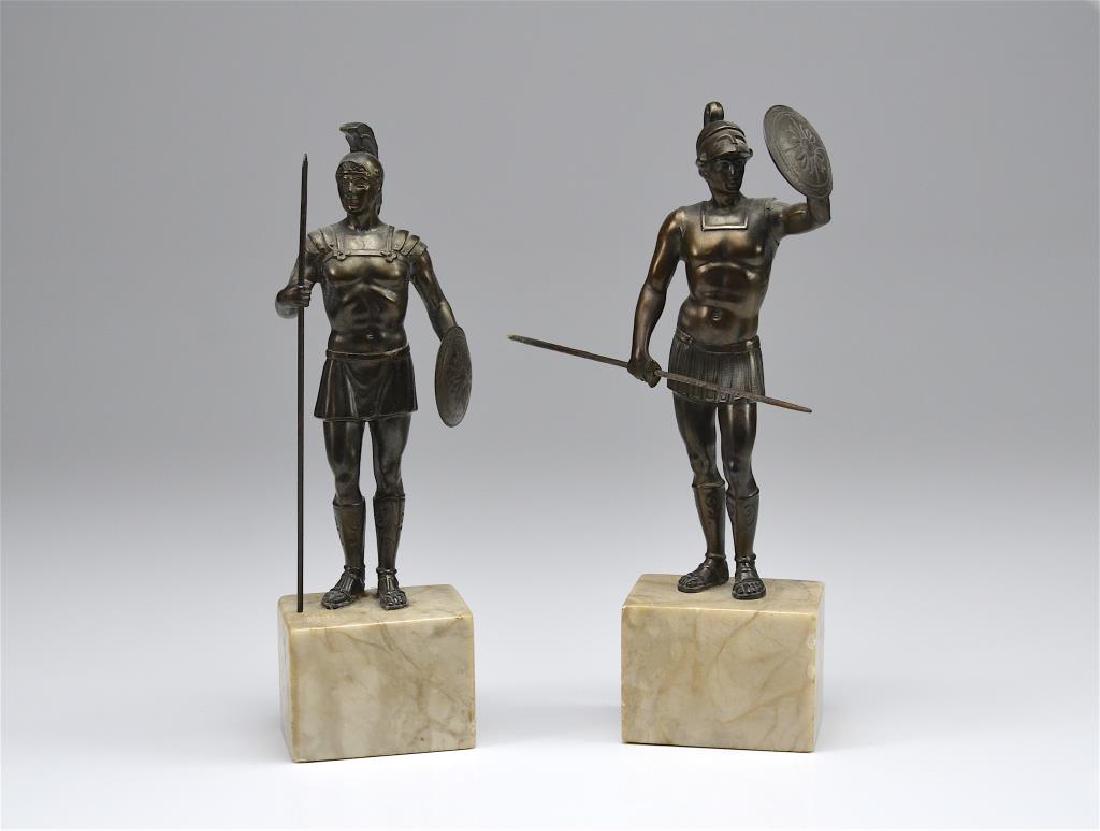Two bronze sculptures of Roman soldiers: Each figure atop a marble base, holding a spear and a shield. H. 26.7 cm (10 1/2 in.)