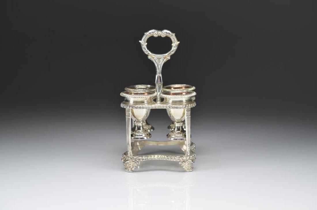 SHEFFIELD PLATE EGG CRUET: Silver plated stand with gadrooned border, holding four urn form egg cups with gold washed interiors. Made by Matthew Boulton. H. 21 cm (8 1/4 in.)