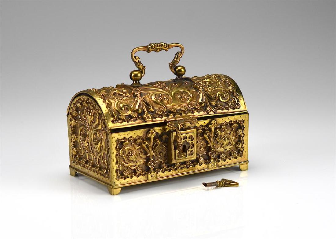 Art Nouveau brass casket: Domed form with foliate decoration and lock and key closure.