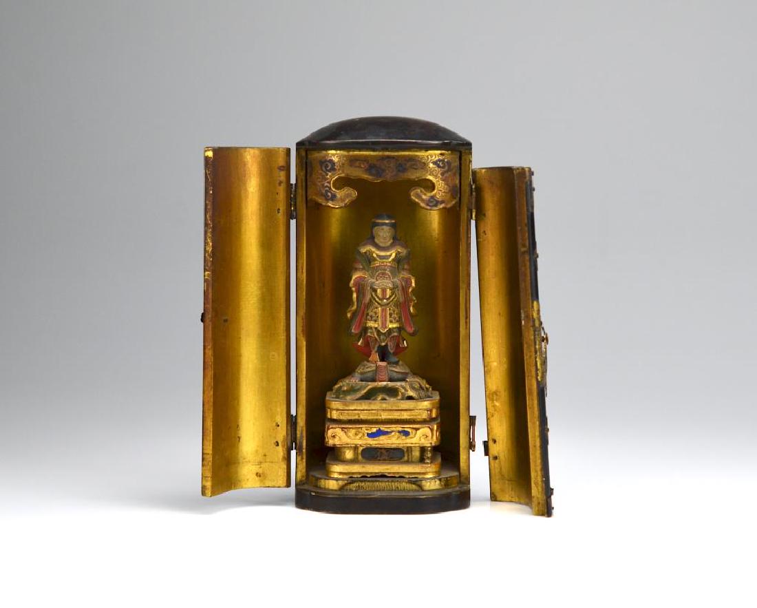 JAPANESE LACQUERED WOOD ZUSHI TRAVEL SHRINE: Black lacquered exterior with gold interior. Housing a figure standing on a turtle. Edo period. H. 18.5cm (7 1/4 in.)