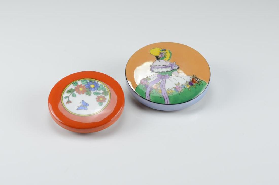 Two Art Deco Noritake powder puff jars: Each lustre glazed, one painted with a French figure.