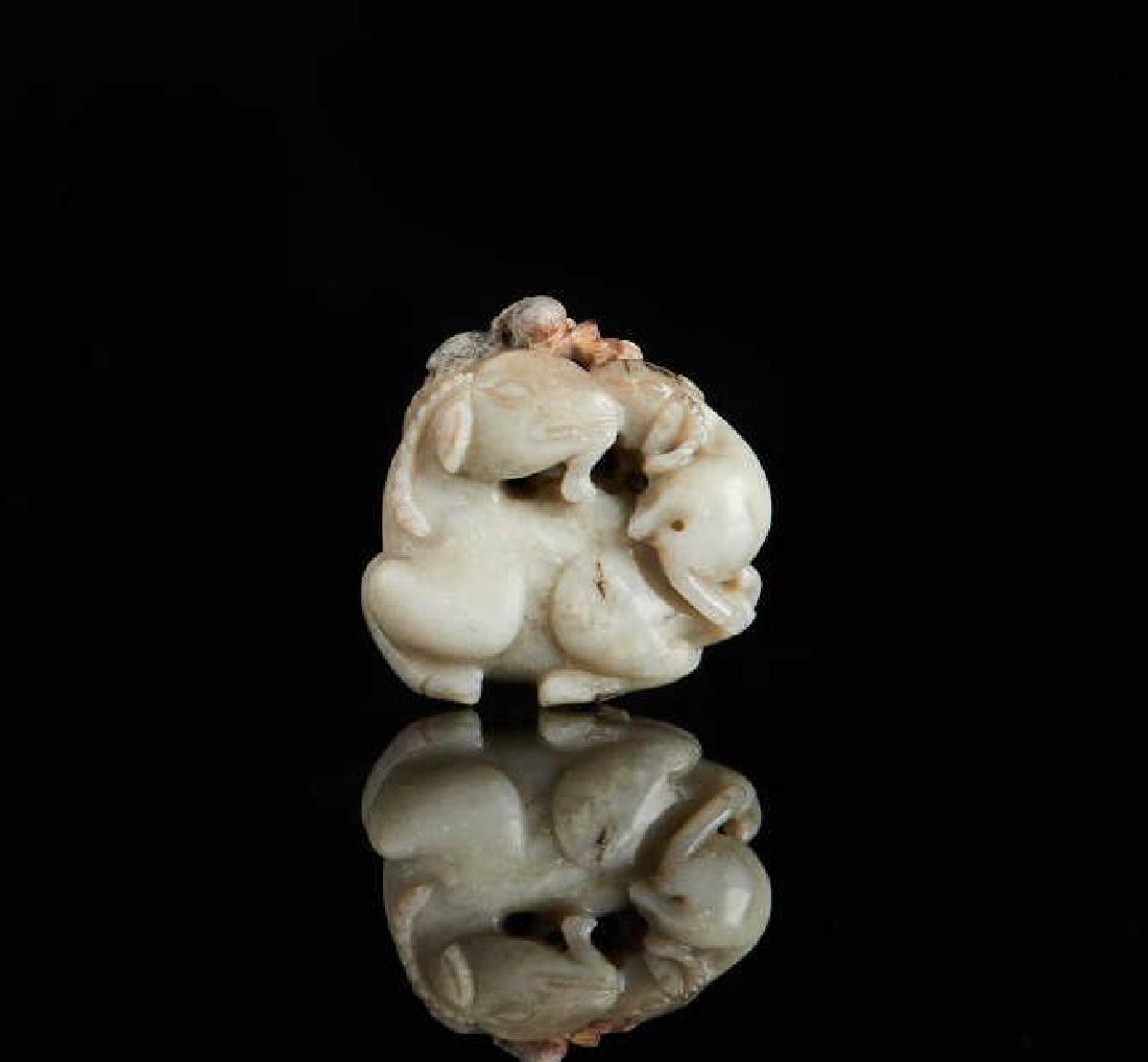 CHINESE JADE CARVED RAM GROUP: Overall in grey to chicken bone white tone, with red and black inclusions. Carved with mother and child ram. With fitted wood stand. Qing dynasty. H. 4cm (1 1/2 in.) Provenance: Chinese jades from the