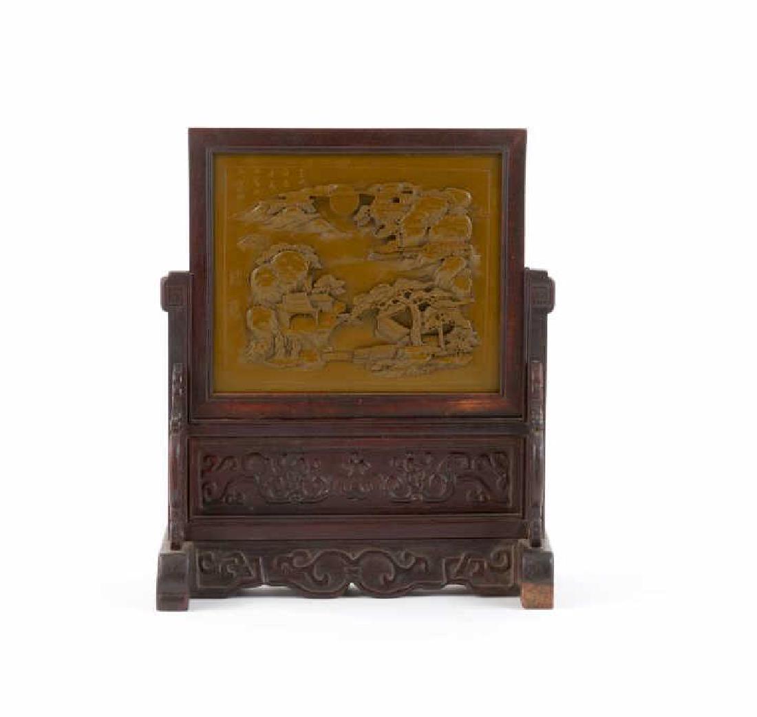 CHINESE YIXING POTTERY PLAQUE FRAMED AS SCREEN: Olive green plaque with mouldd mountain landscape scene, with incised calligraphy to top left, signed Wang Ren. The plaque is framed and inserted into a hardwood carved scholar's stand. Republican per