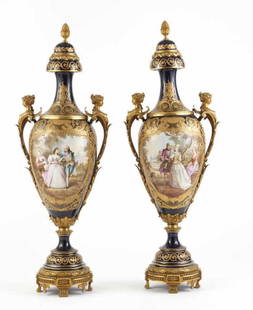 A MONUMENTAL PAIR OF FRENCH PORCELAIN URNS: Cobalt ground with hand painted garden scene of a couple embracing with flowers. Signed Poitevies*. Mounted with ormolu gilt bronze base, figural handles and pineapple finials. Late 19th C. H. 105 cm