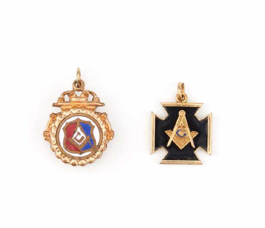 TWO GOLD FILLED MASONIC FOBS: Each with Freemason emblems. One is round with inset enamel symbols and the other is in the form of a Maltese cross. Each side decorated with square and compass symbols.