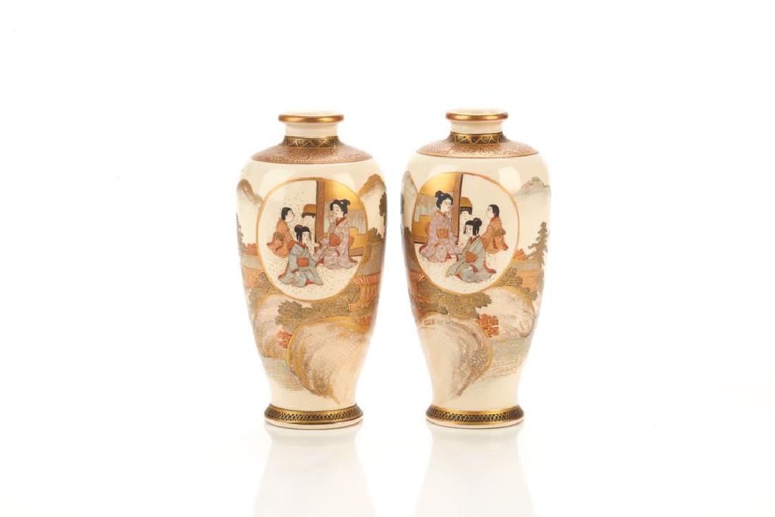 PAIR OF JAPANESE SATSUMA POTTERY VASES: Painted with mountain landscape, with circular cartouches painted with figural family scene. Base marked Hakuzan. Meiji period. H. 16cm (6 1/4 in.)