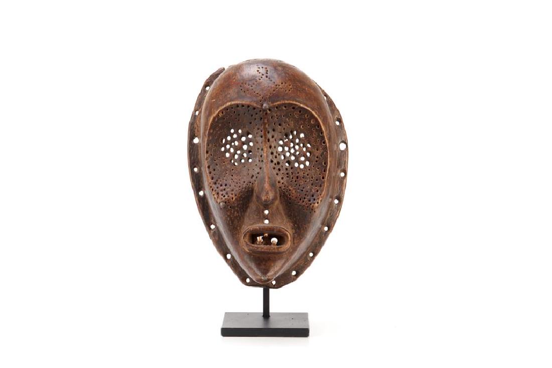 African carved wood tribal mask: Heart shaped with holes and original teeth, probably, Democratic Republic of Congo, East Pende. With metal stand and collection No. L.285. H of mask 35cm (13 3/4in) Provenance: The Collection of Toby 