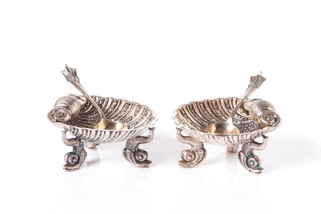 Pair of 19th C English shell form silver salts: 19th C clam shell form bowls raised on three dolphin form feet. Birmingham, 1894. Colen Hewer Cheshire. Together Onlsow pattern spoons. 65g.