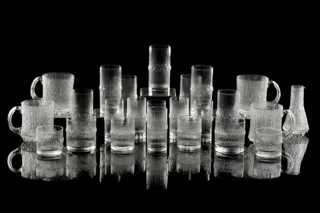 Lot of Tapio Wirkkala Niva Glasses: 29 various glasses, together with four mugs and a small carafe.
