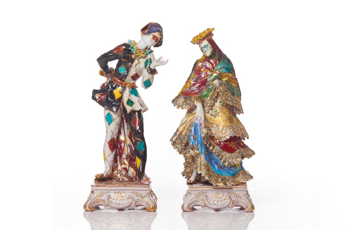 Two Naples Capodimonte porcelain harlequin figures: Of a masked man and a masked woman, each atop a square base. Marks to bases. H. of male: 37.5 cm (14 3/4 in.) Collection from the Ed Mirvish Estate.Condition noted.