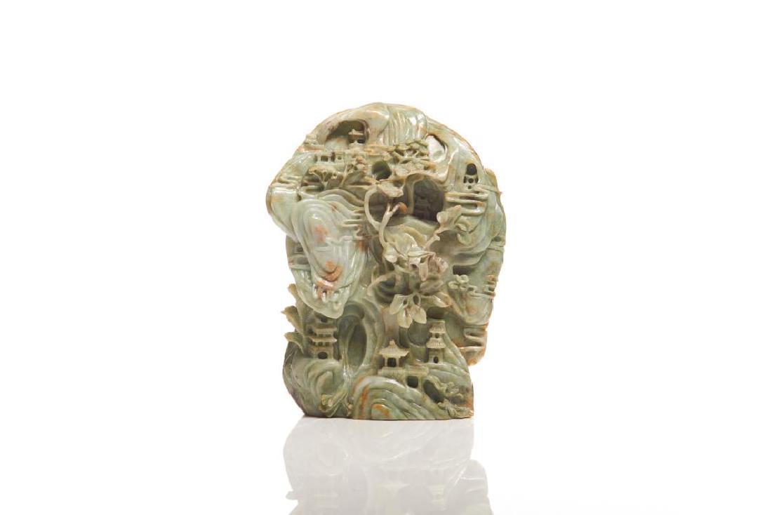 CHINESE CARVED GREEN JADE MOUNTAIN: Overall in pale green tone. Carved as a vertical mountain with architectural details and high relief branches. H. 20cm (8 in.)