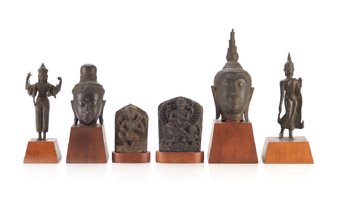 GROUP OF ASIAN BUDDHIST AND HINDU STATUES: Including Two Thai and Cambodian style statues, two Thai style bronze Buddha head on stand, and two Indian schist relief carvings. All with wood stands. Tallest on stand: 33cm (13 in.)
