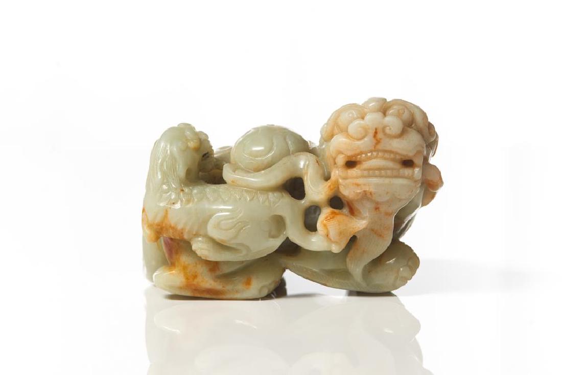 CHINESE JADE CARVED FOO LION GROUP: Overall in pale celadon and grey tone with russet brown inclusions. Carved as a master lion with a lion cub playing a silk ball. L. 23cm (5 1/8 in.)