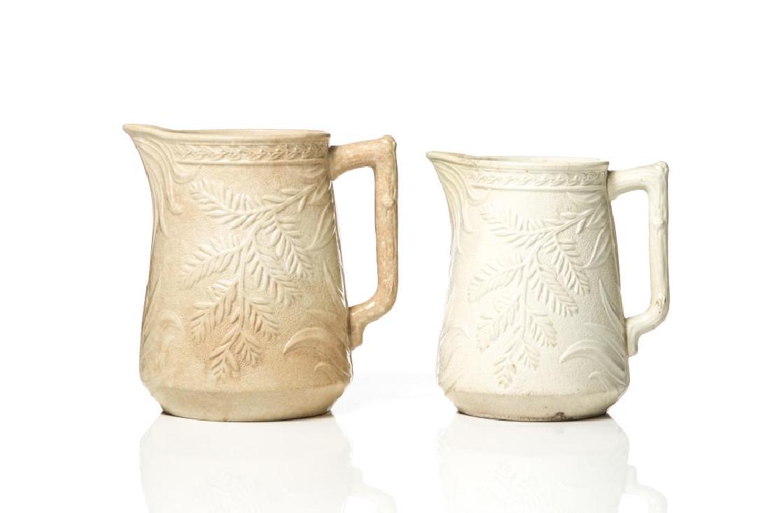 Graduated pair of St. Johns ironstone fern jugs: relief molded decoration, printed Stone Chinaware Co. marks, H. 20 cm (8 in.) hairline to smaller jug