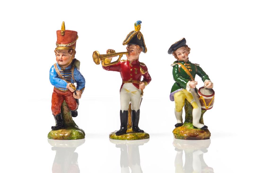 Three Dresden porcelain soldier boy figures: Two playing instruments and one with sword, faux Meissen marks, early 20th C. H 5 1/4in. Restored trumpet, missing drumming battons