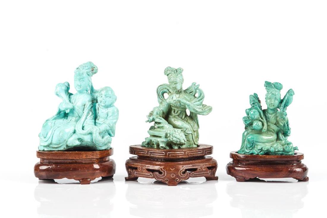 THREE CHINESE TURQUOISE CARVED LADIES: Two carved with an individual lady. One carved with a mother and child group. All with fitted wood stands. Tallest: 8.5cm (3 3/8 in.)