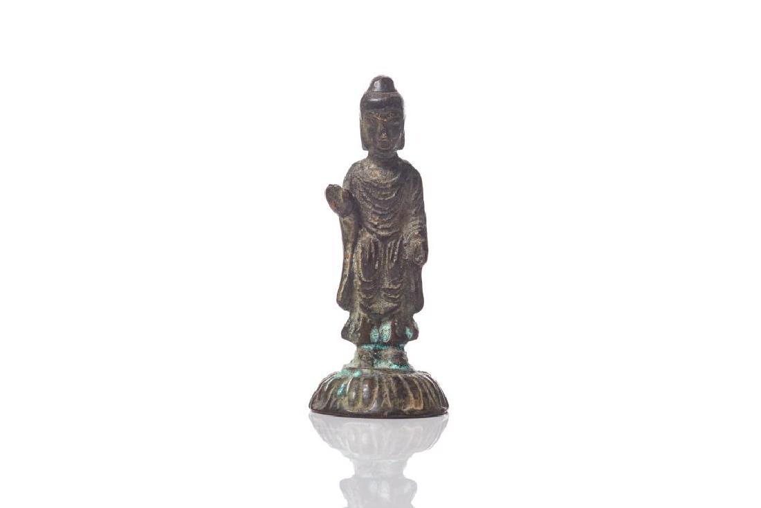 KOREAN SILLA PERIOD SMALL BRONZE BUDDHA: Standing on a lotus base with hands in abhayamudra and varadamudra, fine folds to robe. H. 8cm (3 1/8 in.) Weight: 73g.