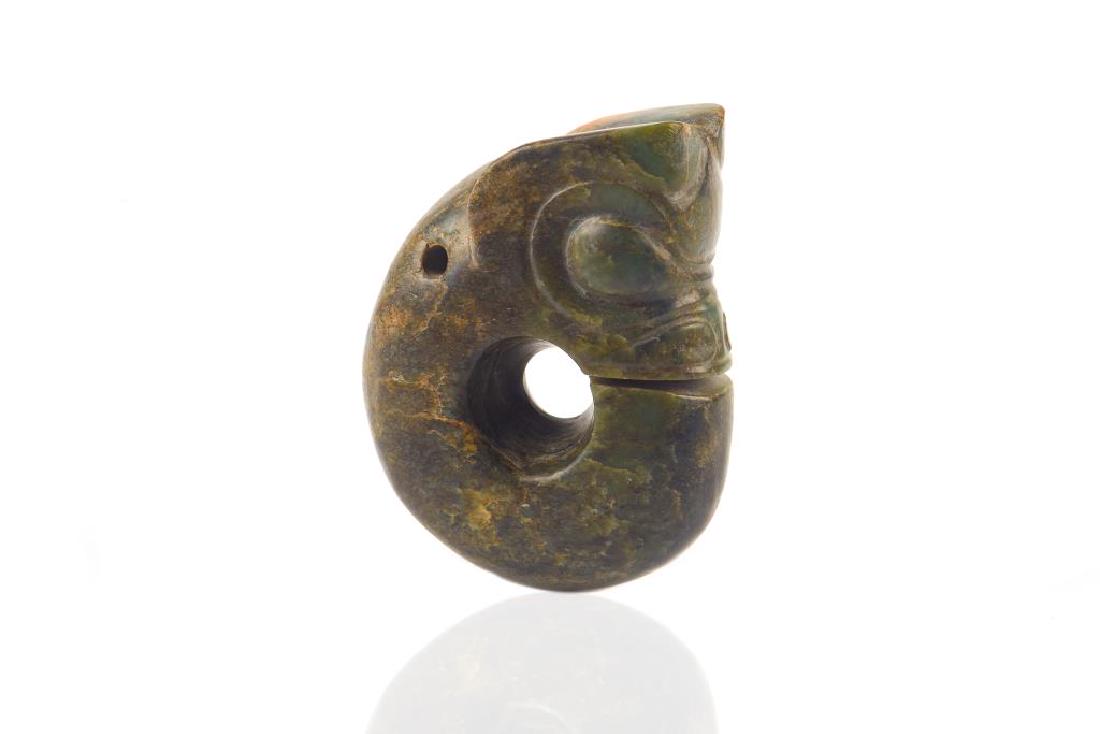 CHINESE HONGSHAN CULTURE STYLE JADE PIG DRAGON: The jade in dark green celadon tone with moss green and spinach inclusions to one side and russet red to the other. Carved as a coiled stylized mythical animal, pierced with a circularaperture to back