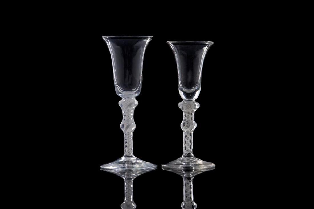 NEAR PAIR OF ENGLISH GEORGIAN AIR TWIST WINES: The glasses with double knop stems, double series multi spiral twisted with opaque white exterior spirals, trumpet bowls, 18th C.H. of taller 15.5cm (6 1/8in.) popped air bubble to base of one. chip t