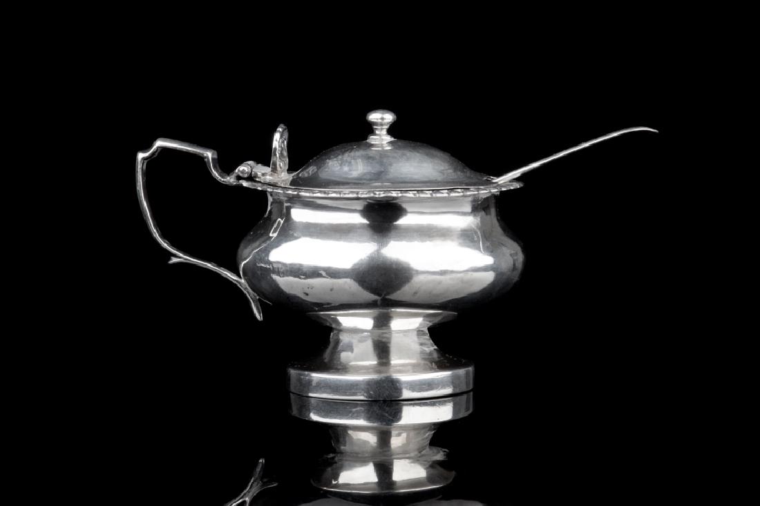 GEORGE III SILVER MUSTARD POT & SPOON: A plain design with egg and dart border. Marks on body rubbed, date letter, and passant on lid. London, 1820. Together with mustard spoon. William Eley, London, 1817. 151g H. 7cm (2 3/4 in.)