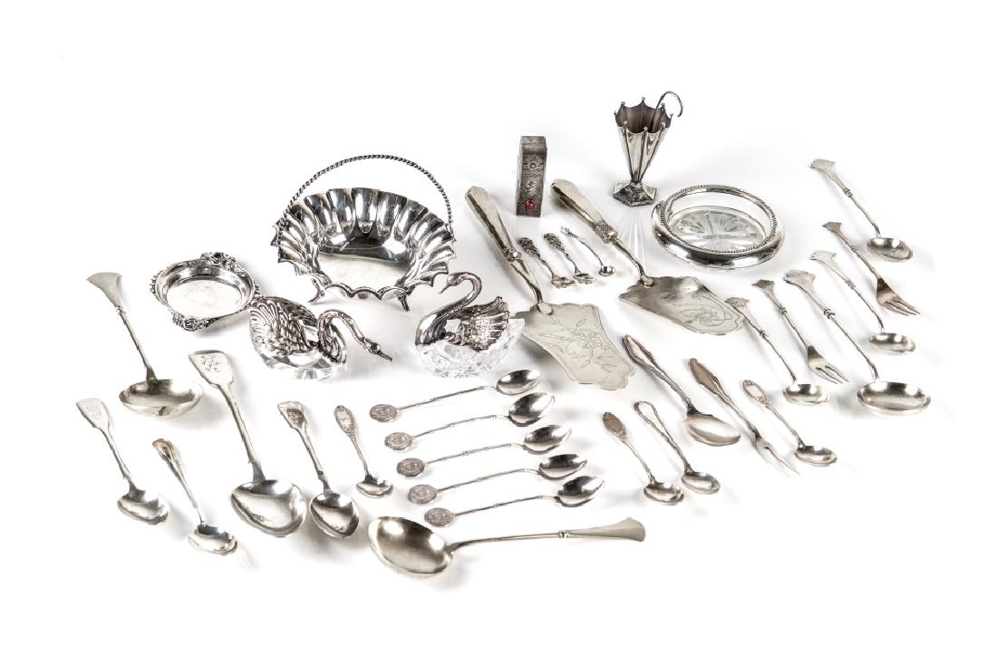 GROUP OF SILVER & GLASS TABLE ACCESSORIES: 33 pieces, comprising a condiment basket, two silver and glass swan salt cellars marked sterling, a umbrella stand toothpick holder, a silver lipstick holder, two Russian silver cakeservers, a small d