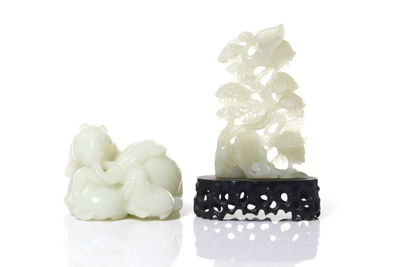 TWO CHINESE JADE CARVINGS: Overall in white to light celadon tone. Carved as a crane and pine plaque, and a ram group. Plaque height on stand: 16cm (6 1/4 in.)