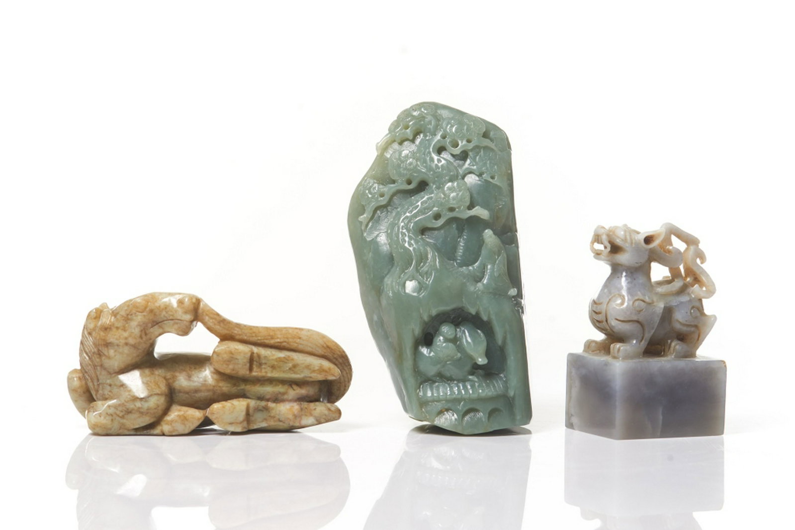 THREE CHINESE JADE CARVINGS: Including a celadon jade mountain with figure and landscape. A reclined horse figure. A square seal with mythical beast top. Tallest: 13.5cm (5 3/8 in.)