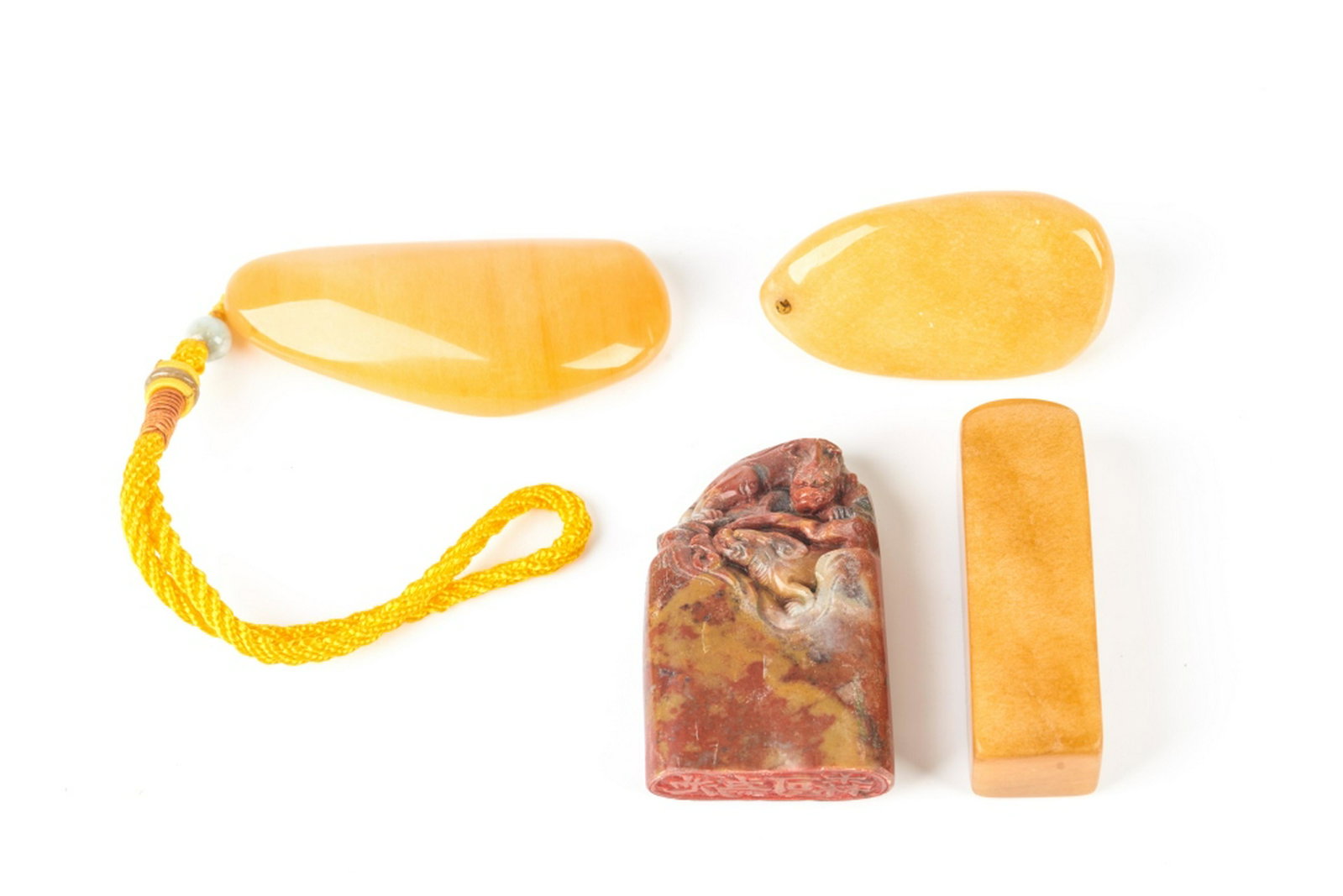 FOUR CHINESE SOAPSTONE SEALS AND TOGGLES: Including 1 yellow seal, 2 yellow toggles, and 1 red and yellow soapstone seal with dragon carving to top. Tallest: 9cm (3 1/2 in.)