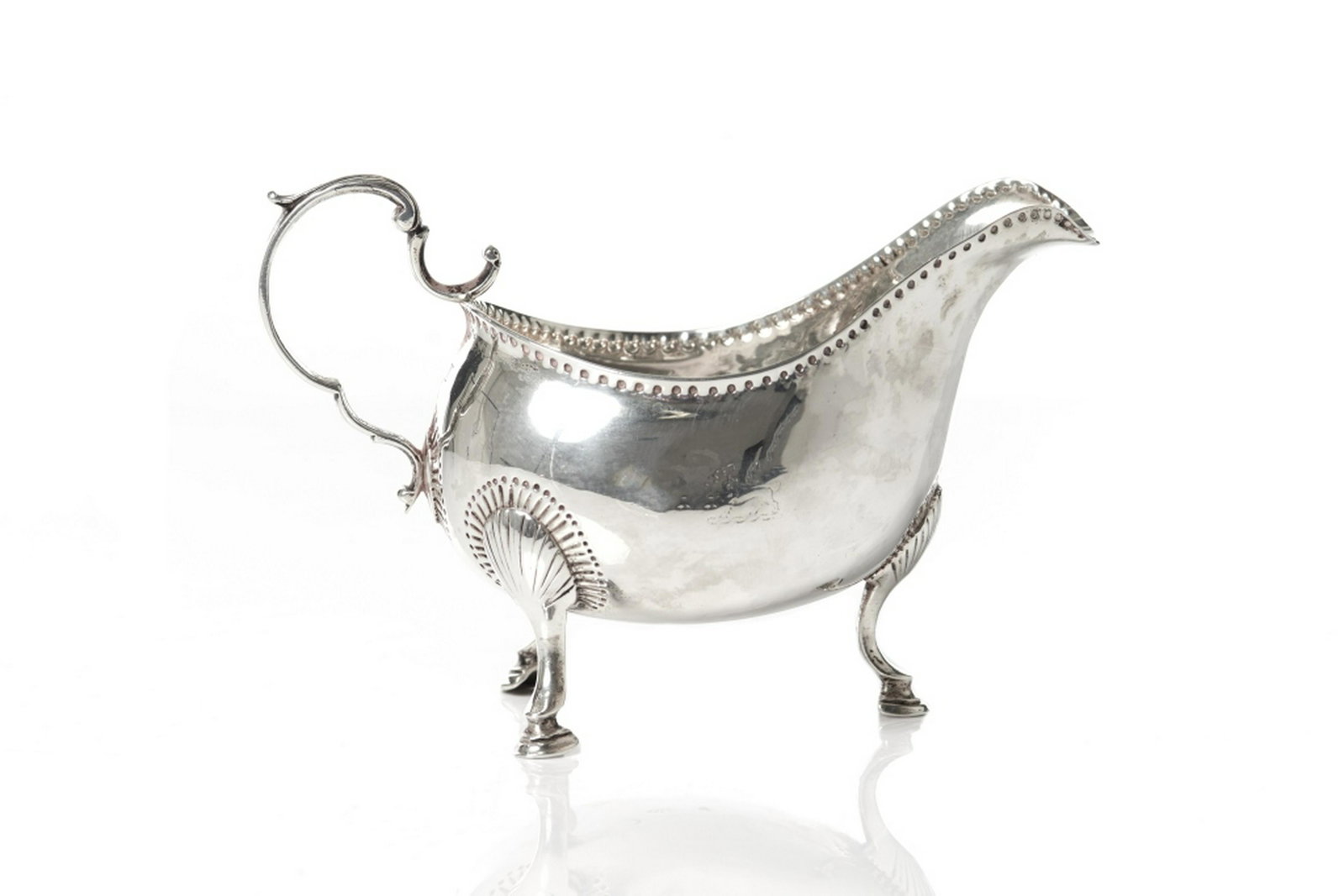 GEORGIAN IRISH SAUCE BOAT: An 18th C George III sterling silver sauce boat raised on three legs terminating in hooves. Matthew West, Dublin, c.1770. 174g