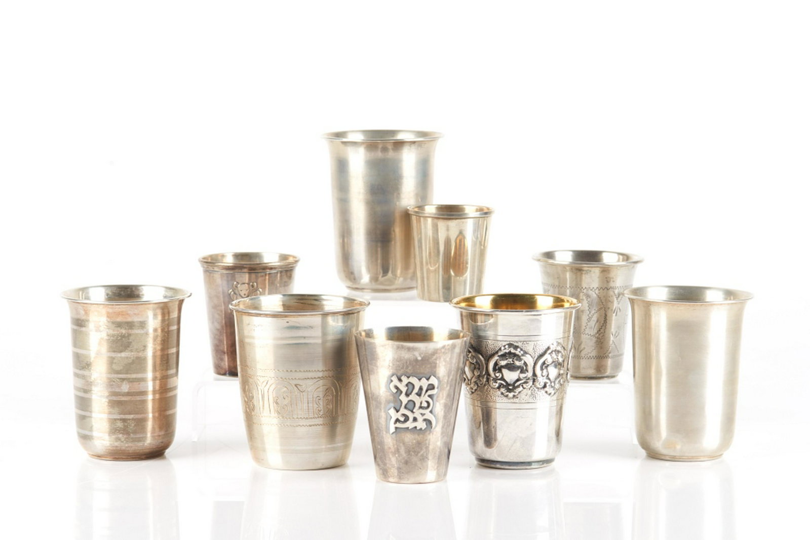 LOT OF ASSORTED SILVER BEAKER CUPS: 9 cups by various makers, including pieces from Spain, Portugal, and America. Some with Judaica kiddush cup interest. 433g H. of tallest cup: 8.5 cm (3 3/8 in.)
