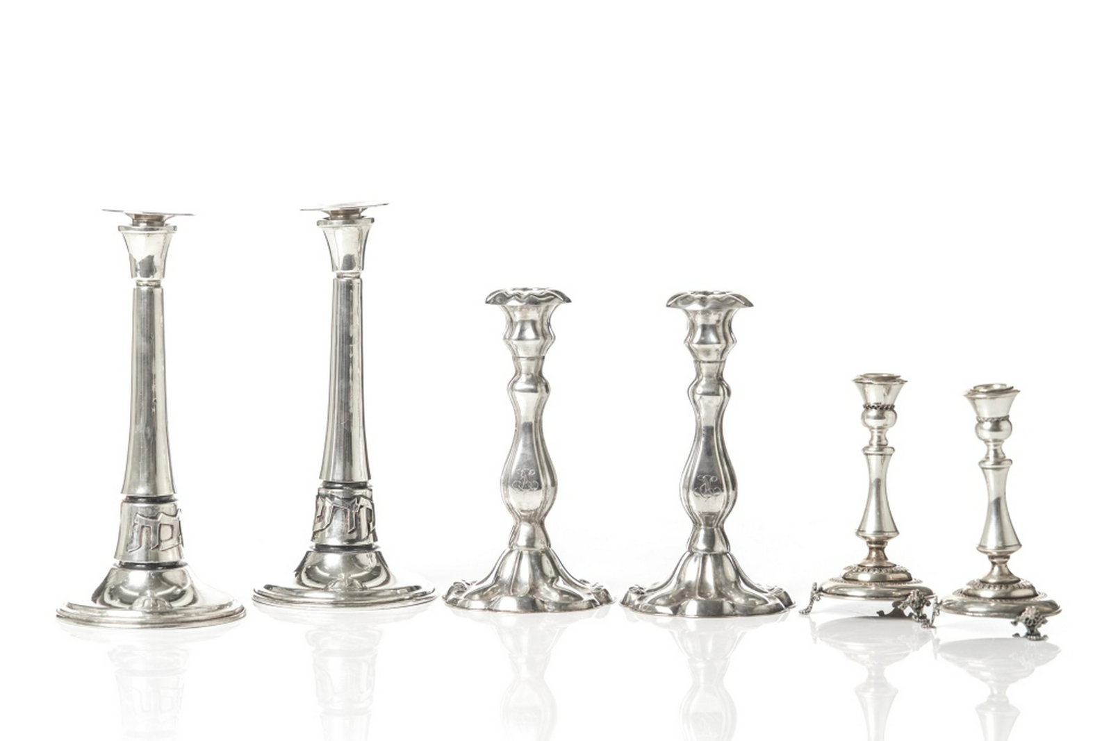 THREE PAIRS OF SILVER CANDLESTICKS: One pair of Judaica candlesticks (with removable bobeches), one pair of hallmarked Finnish silver candlesticks, and one pair of silver Judaica candlesticks marked Ben Zion Sterling.