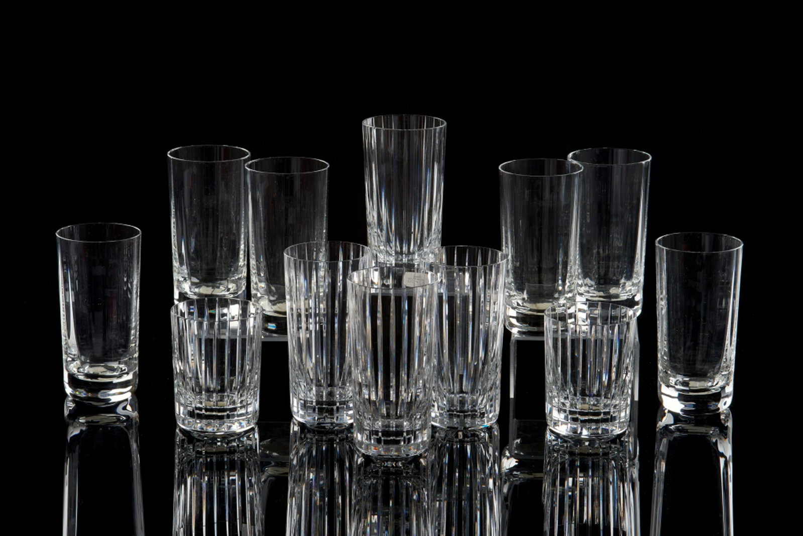 GROUP OF BACCARAT CRYSTAL BARWARE: Collection includes 12 glasses in total. One complete set of Perfection highball drinking glasses, 6 in total (H. 14 cm) with original box. Additionally, a set of Harmonie Barware including 4 tall hig