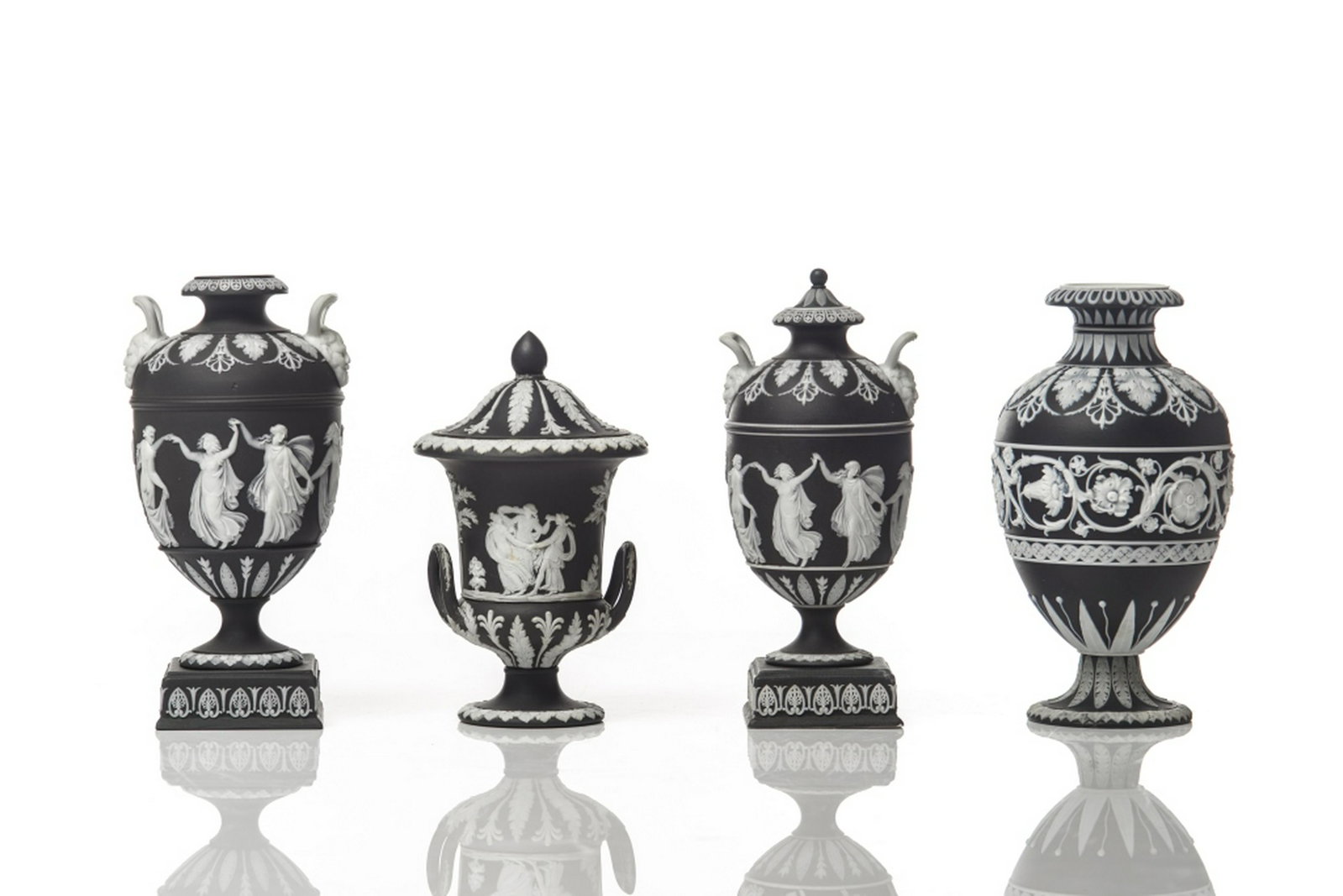 LOT OF BLACK WEDGWOOD JASPERWARE URN FORM VASES: 4 in group total black ground with white classical overlay, including 2 footed vases with square bases and double handles, plus two additional footed vases in various sizes. H. of tallest 16.5 cm (6 1