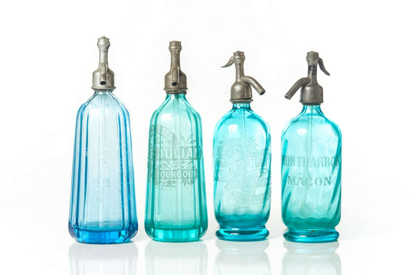 FOUR FRENCH BLUE GLASS SELTZER BOTTLES: Each with etched French inscriptions and metal mounts. H. of tallest: 32.4 cm (12 3/4 in.)