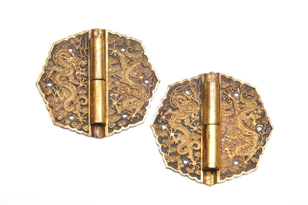 PAIR OF IMPERIAL CHINESE GILT BRONZE DRAGON HINGES: 清 銅鎏金合頁 Each of a two-part folding hinge cast with fine five-claw dragons flying in clouds. Each pair with six mounting holes. Qing dynasty, probably 18th C.