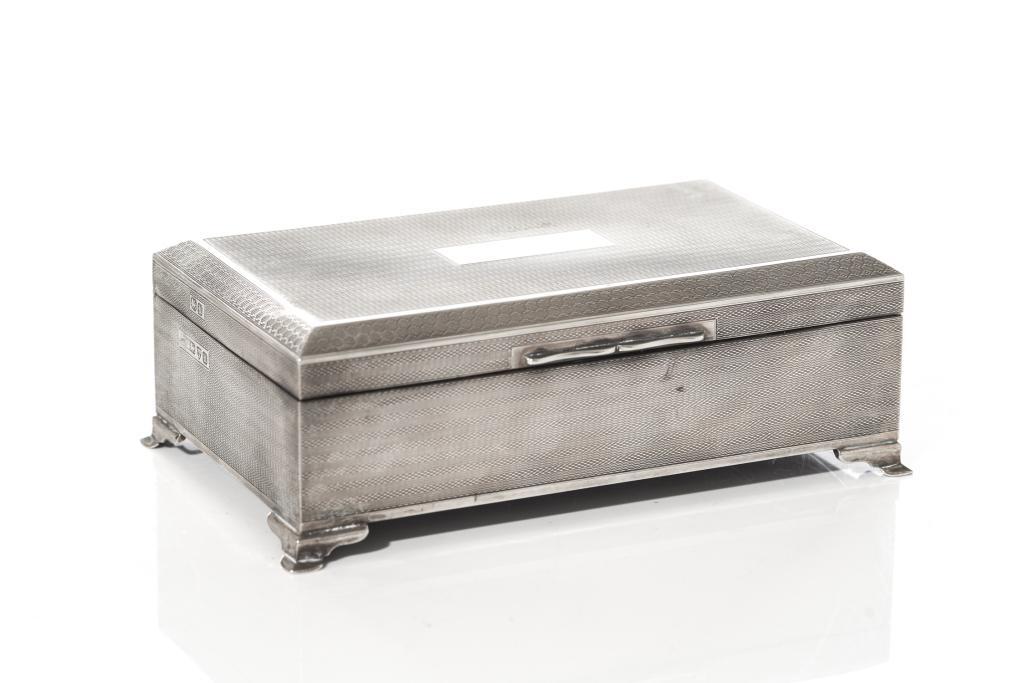 CEDAR LINED SILVER BOX WITH ENGINE TURNED PATTERN: Interior includes two compartments. Stamp marks dating Chester, 1945. H. 6 cm (2 3/8 in) W. 17.5 cm (6 7/8 in).
