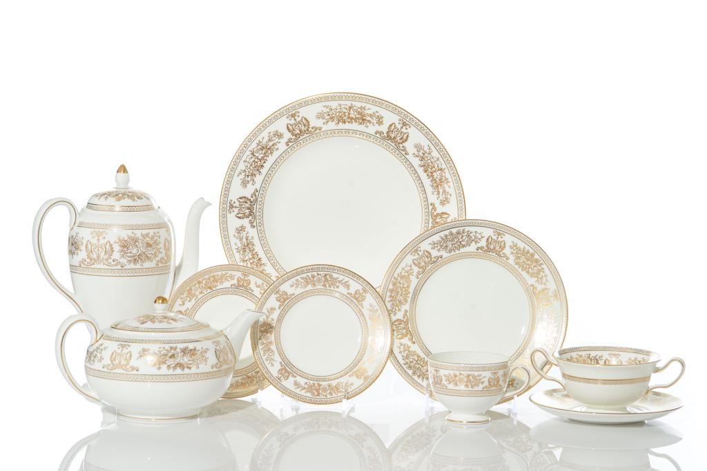 WEDGWOOD GOLD COLUMBIA DINNER SERVICE: Gold griffons and flowers on a white ground. 96 pieces, comprising one teapot, one coffee pot, fifteen dinner plates, fifteen luncheon plates, six footed cream soups and saucers, seventeen bread and b