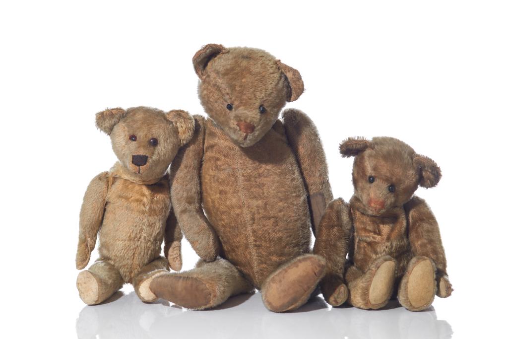 THREE ANTIQUE STEIFF TEDDY BEARS: A larger and two smaller bears with glass and beaded eyes, reticulated arms and legs and mohair fur bodies. c. 1915. Worn with some signs of repair. Ear tags missing. H. 23.5 in. (largest)