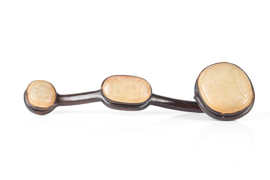 CHINESE WOOD RUYI SCEPTER WITH JADE PLAQUES: Head of scepter inset with an oval plaque carved with an bat and peaches scene. The shaft and end inset with smaller oval plaques carved with Buddha hand citron to one and pomegranate to the other. Qi