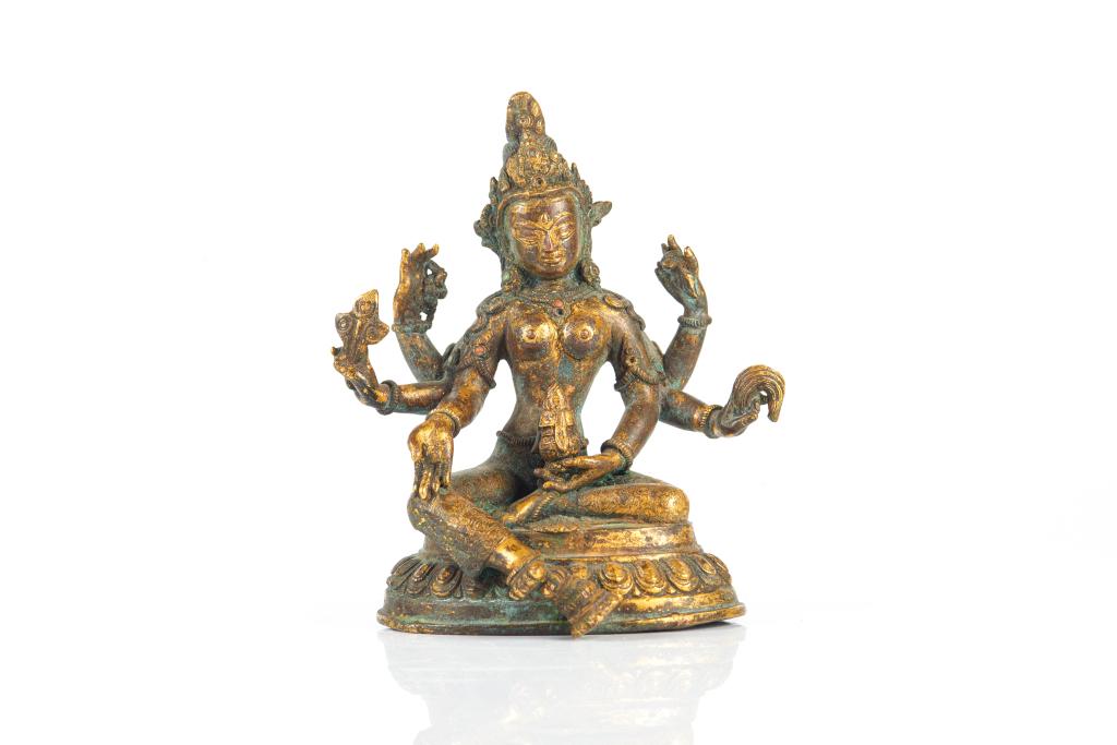 18TH C. NEPAL GILT BRONZE FIGURE OF VASUDHARA: Seated in lalitasana on a lotus base, her six arms radiating around her and holding her attributes. Fine details to clothing and inset with precious stones. H. 17.5cm (6 7/8 in.)