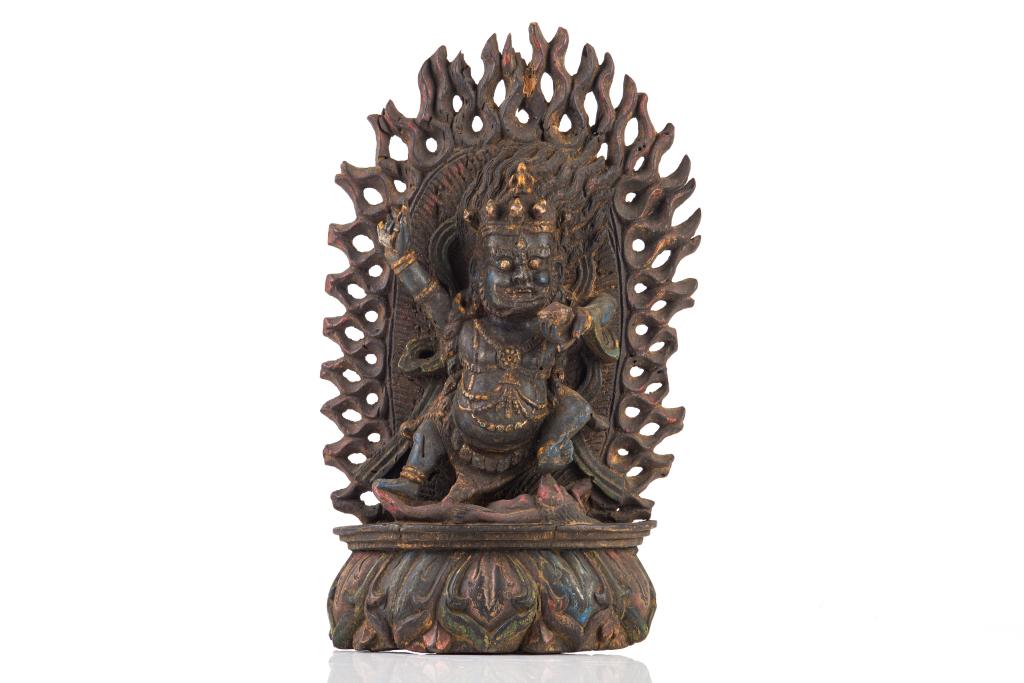 19TH C. TIBETAN POLYCHROME WOOD MAHAKALA: The wrathful figure in alidhasana trampling over a figure, with his arms outstretched and holding implements. Backed by a flaming mandorla and supported on a lotus base. H. 42cm (16 1/2 in.)