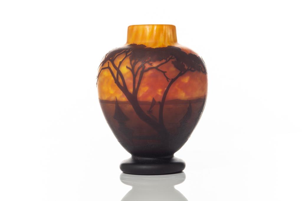 DAUM NANCY CAMEO GLASS VASE: Art Nouveau, small orange ground vase with a landscape scene of trees in front of sailboats on water. Inscribed Daum Nancy on the side of body. H. 17 cm (6 5/8 in.)