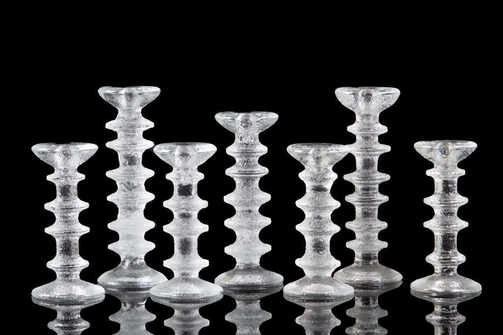 GROUP OF TIMO SARPANEVA FINNISH GLASS CANDLESTICKS: Seven Finnish glass crystal candlesticks of varying heights. Most signed on the bottom TS. H. of tallest pair: 25.1 cm (9 7/8 in.)
