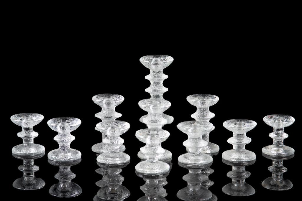 GROUP OF TIMO SARPANEVA FINNISH GLASS CANDLESTICKS: Eleven Finnish glass crystal candlesticks of varying heights. Most signed on the bottom TS. H. of tallest: 15.5 cm (6 1/8 in)