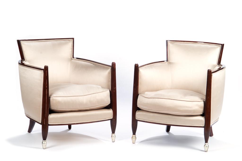 PAIR OF FRENCH ART DECO ARM CHAIRS: With raised backs and high curved arms. Framed in walnut with silver painted caps at front of arms and front of legs. Pearl grey satin upholstery. In the manner of Jules Leleu. H. 29 1/2 W. 24 D. 27 i