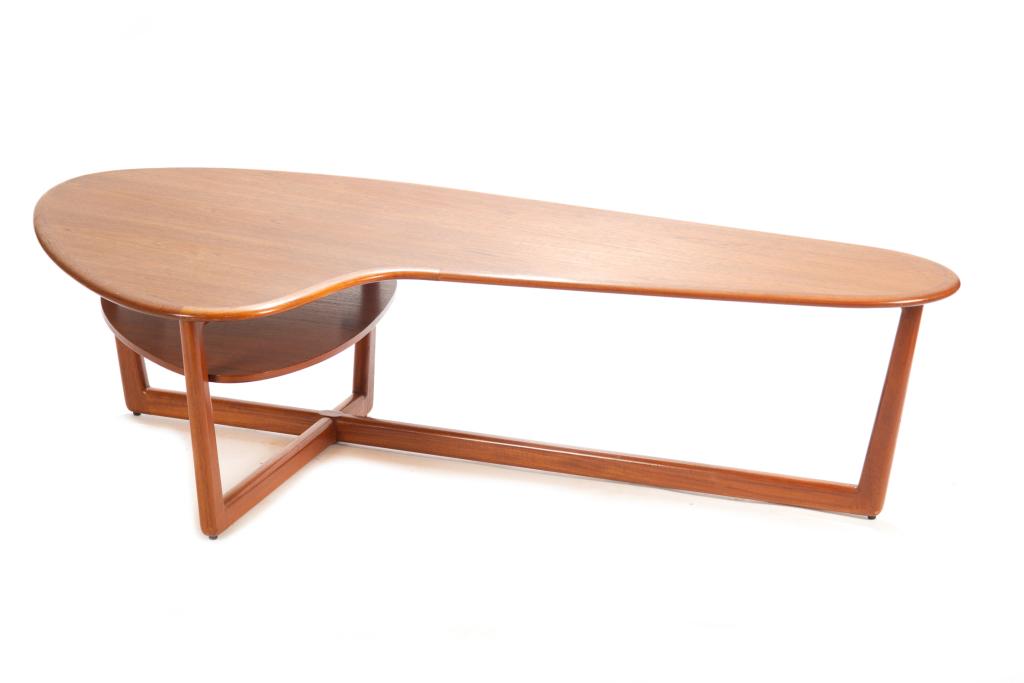 CANADIAN TEAK KIDNEY SHAPED COFFEE TABLE: Kidney-shaped table with rounded clean lines. Mid-century. Lower shelf in rounded triangular shape under larger end. Asymmetrical cross support at base. H. 17 W. 64 1/2 D. 34 in.