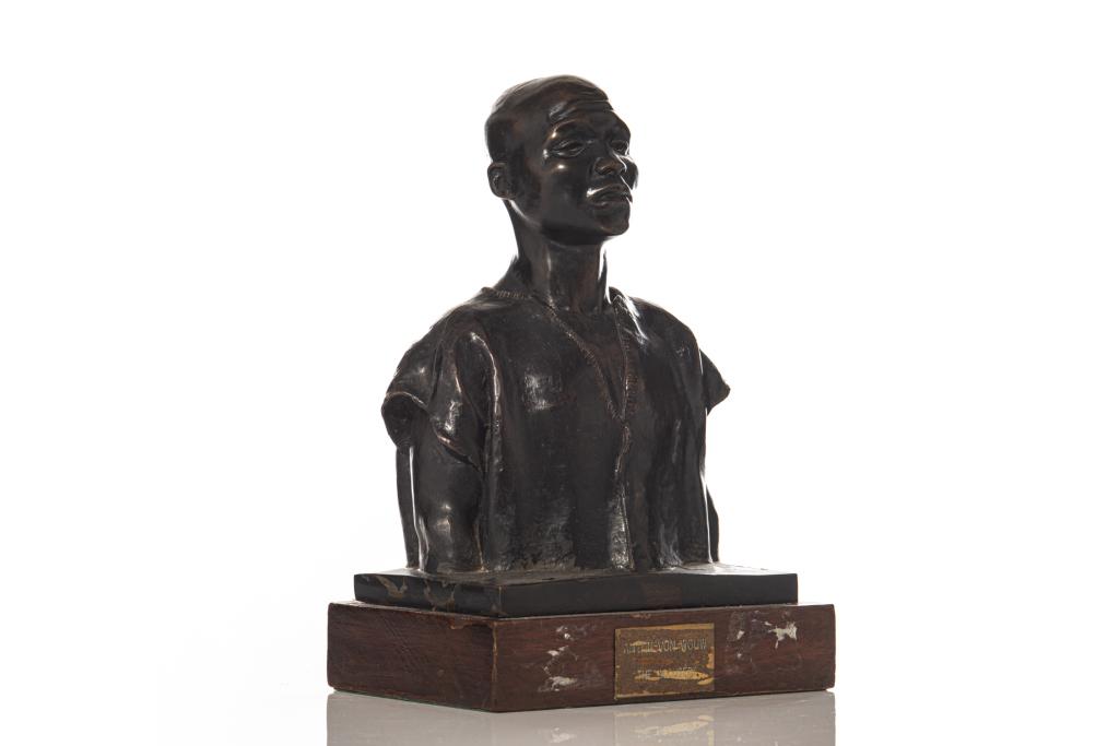 After VAN WOUW, ANTON (Dutch, 1862-1945): Titled "The Accused". Bronze bust of a man with brown patina, mounted on a wood base. Inscribed on back left shoulder of figure with artist name, and engraved brass name plaque on the front of the bas