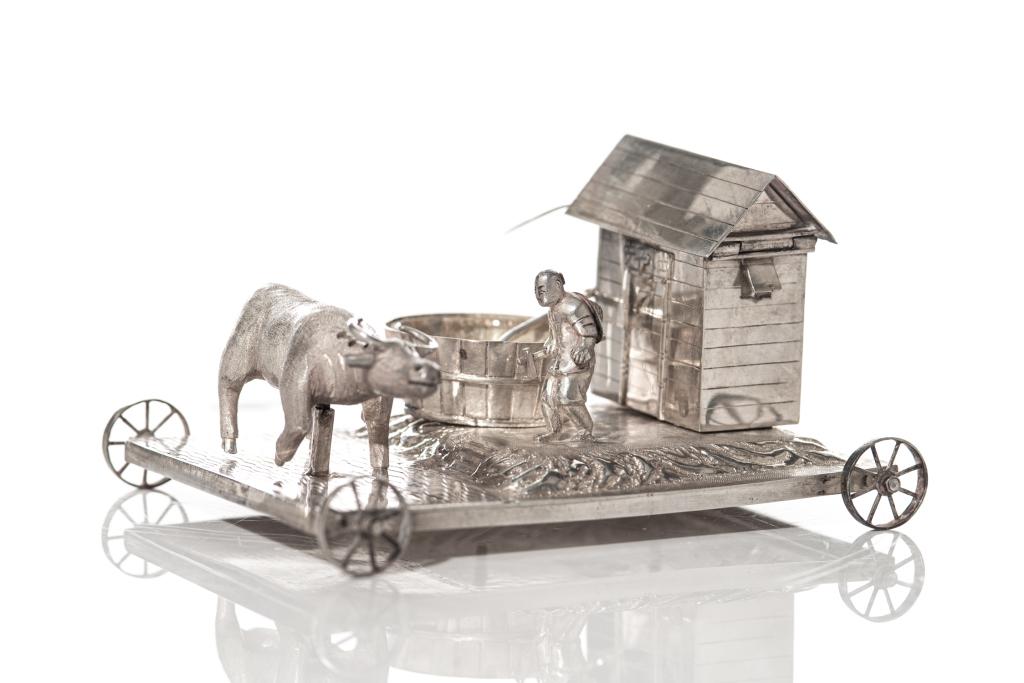 CHINESE EXPORT SILVER FIGURAL CONDIMENT SET: Set includes a pepper shaker, open salt pot and covered mustard pot. A platform with wheels showing a figure alongside a cow, well and house. Stamp marks on underside indicate Wang Hing as maker. H. 6