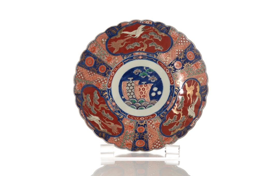 LARGE JAPANESE IMARI PORCELAIN CHARGER: Chrysanthemum form body painted cranes, pine trees, and boats to center. Meiji period. Dia. 46cm (18 in.)