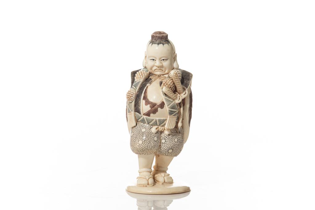 JAPANESE STAINED NATURAL CARVING OF A MAN: Carved as a man with rounded belly and two swords strapped to the left side. Signed in red to base. 19th to early 20th C. H. 14.5cm (5 3/4 in.) BIDDERS LIVING OUTSIDE OF CANADA are warned to proceed w